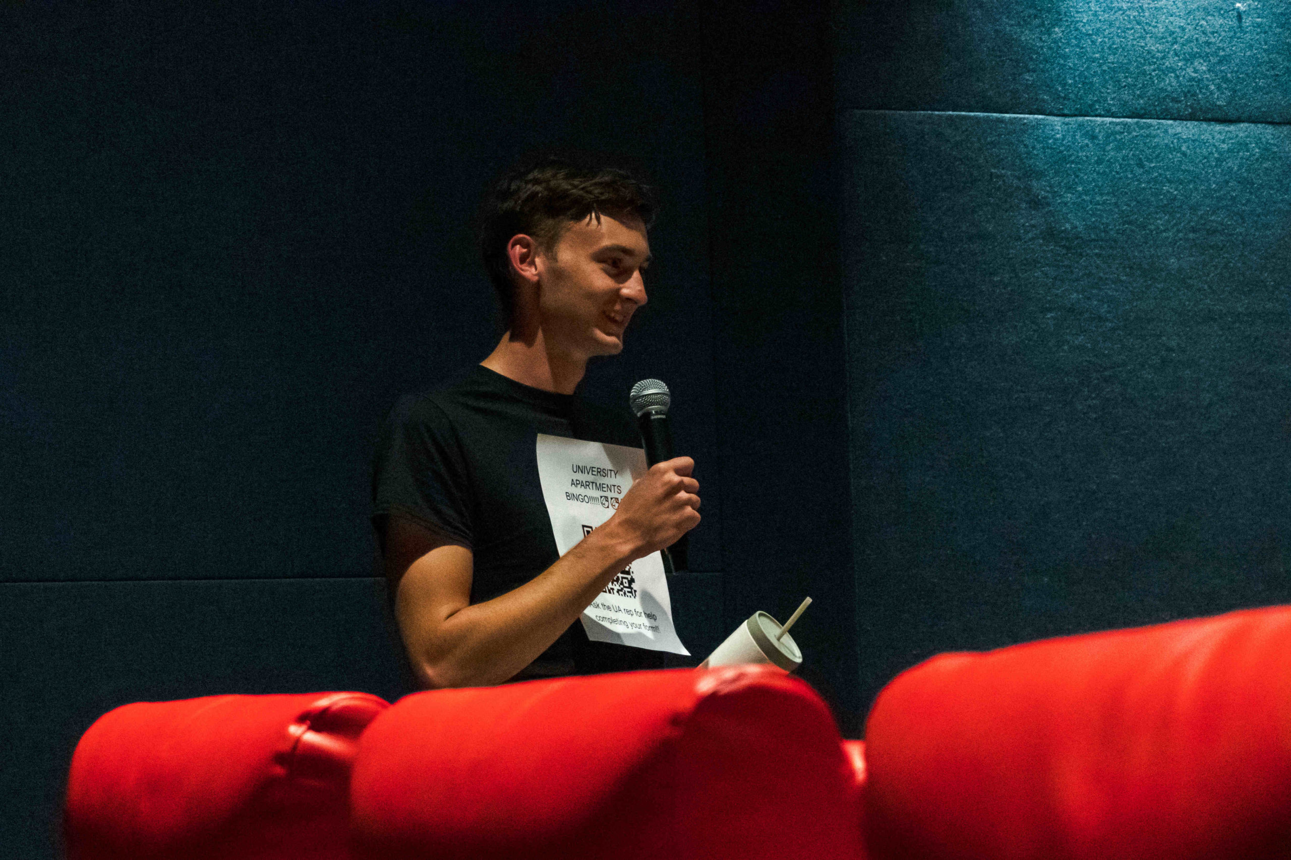 UA employee with microphone talking in movie theater